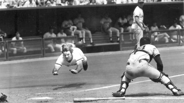 Pete Rose sliding head-first into home plate 
